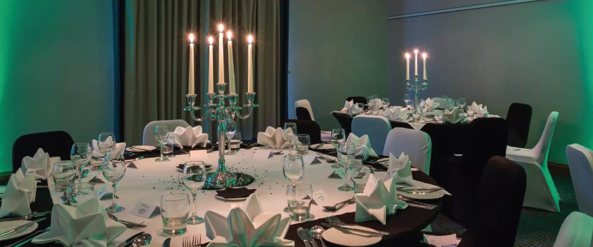 A wedding table set up with a central glass flower arrangement.