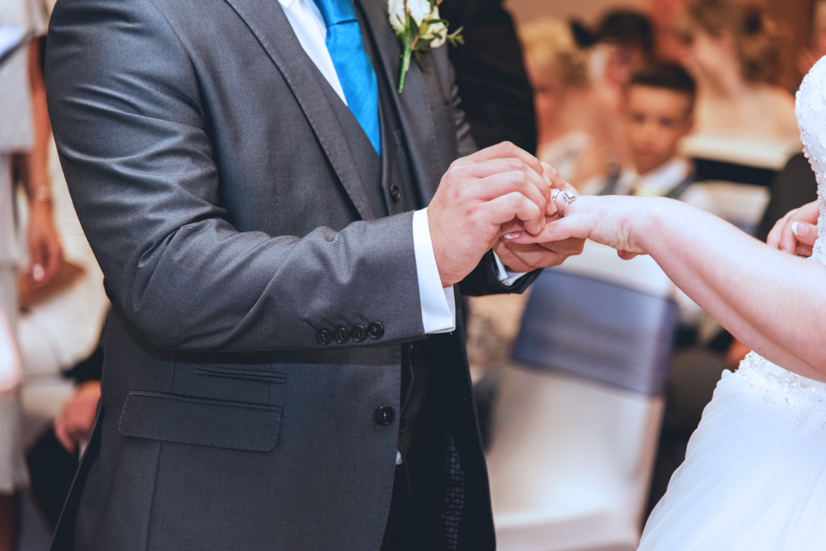 wedding venue northampton bride and groom placing rings on finger.