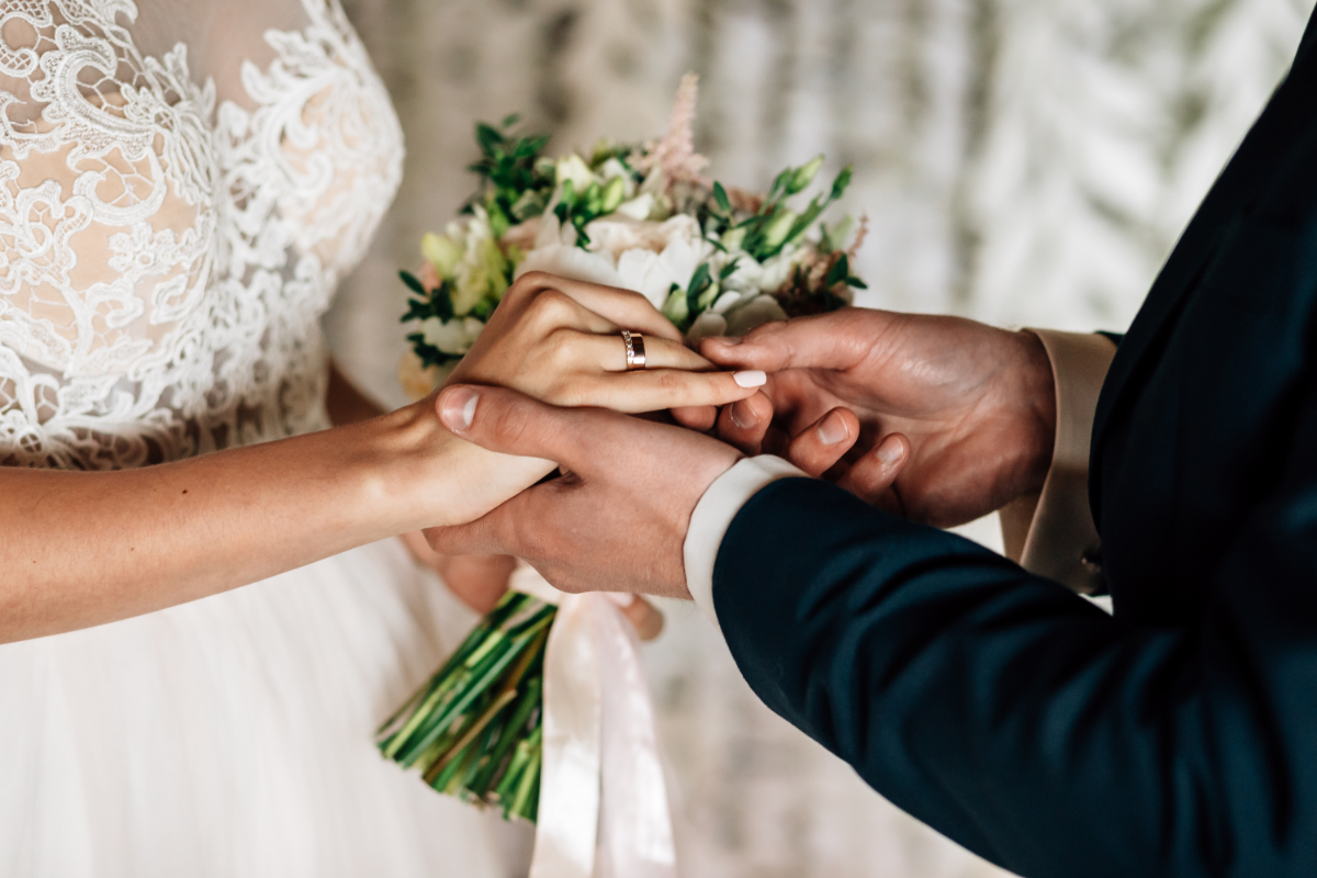 wedding venues rugby northampton bride and groom placing rings on finger.